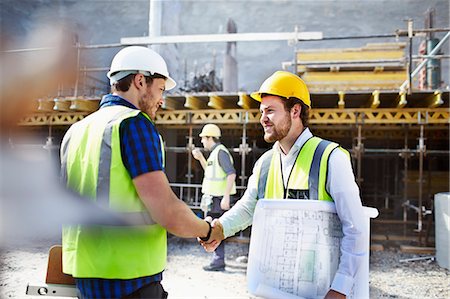 Construction worker and engineer with blueprints handshaking at construction site Photographie de stock - Premium Libres de Droits, Code: 6113-08321751