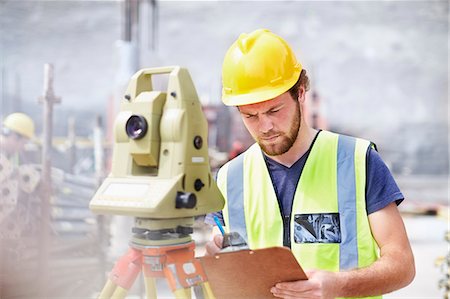 simsearch:6113-08321753,k - Engineer with clipboard behind theodolite at construction site Stock Photo - Premium Royalty-Free, Code: 6113-08321757