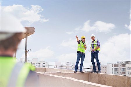 Construction worker and engineer talking at highrise construction site Fotografie stock - Premium Royalty-Free, Codice: 6113-08321765