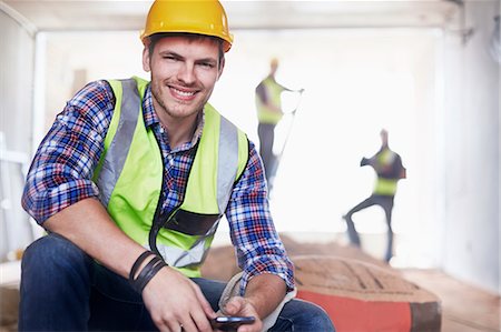 Portrait smiling construction worker with cell phone at construction site Photographie de stock - Premium Libres de Droits, Code: 6113-08321773
