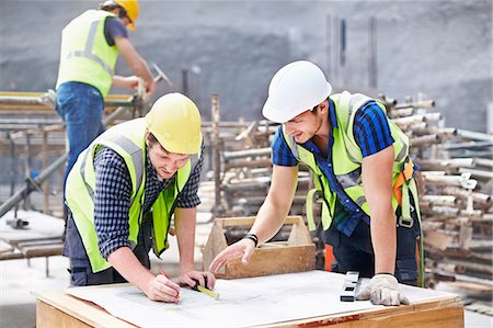 Construction worker and engineer revising blueprints at construction site Stock Photo - Premium Royalty-Free, Code: 6113-08321774