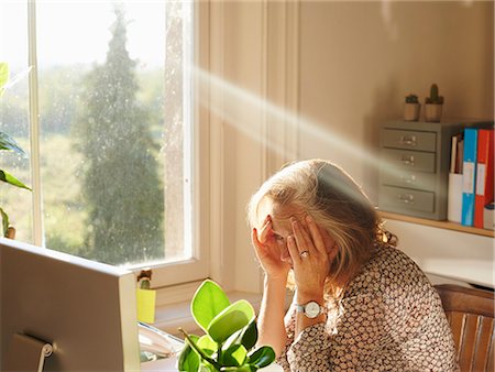 struggling - Stressed woman using computer in sunny home office Stock Photo - Premium Royalty-Free, Code: 6113-08321791