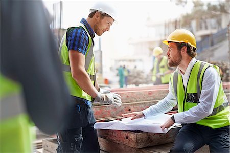 safety construction - Construction worker and engineer reviewing blueprints at construction site Stock Photo - Premium Royalty-Free, Code: 6113-08321712