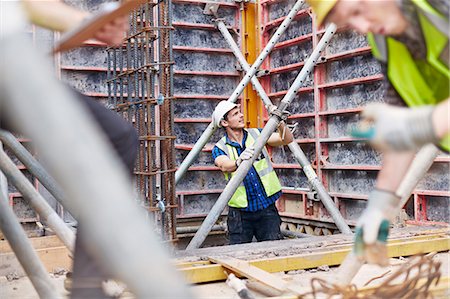 simsearch:6113-08321732,k - Construction worker examining structure at construction site Foto de stock - Royalty Free Premium, Número: 6113-08321718