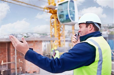 simsearch:6113-08321771,k - Construction worker with walkie-talkie at construction site Foto de stock - Royalty Free Premium, Número: 6113-08321737
