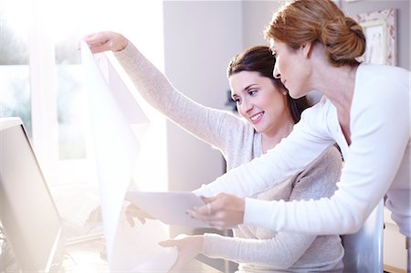 designer female working with computer - Interior designers with digital tablet discussing blueprints in office Stock Photo - Premium Royalty-Free, Code: 6113-08424164