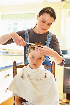 die stirn in falten legen - Portrait unhappy boy getting haircut from mother in kitchen Stockbilder - Premium RF Lizenzfrei, Bildnummer: 6113-08424187