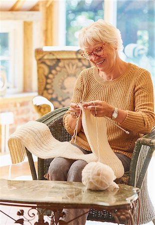 Smiling senior woman knitting scarf Foto de stock - Sin royalties Premium, Código: 6113-08424254