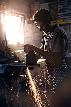 safety glasses - Blacksmith using saw in forge Stock Photo - Premium Royalty-Free, Code: 6113-08424319