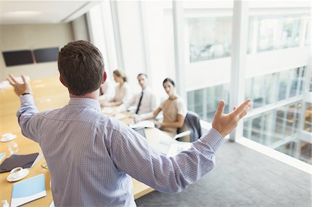 simsearch:6113-08220347,k - Businessman gesturing to colleagues in conference room meeting Stock Photo - Premium Royalty-Free, Code: 6113-08549970