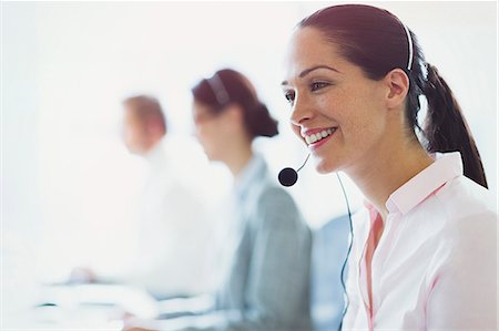 simsearch:6113-07243069,k - Smiling businesswoman talking on the phone with headset Stock Photo - Premium Royalty-Free, Code: 6113-08549980