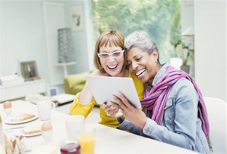 skype - Laughing mature women sharing digital tablet at breakfast table Foto de stock - Sin royalties Premium, Código: 6113-08550041