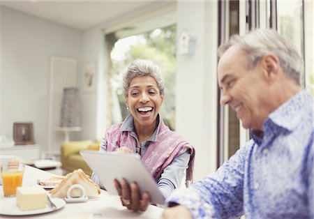 skype - Mature couple laughing and using digital tablet at breakfast table Foto de stock - Sin royalties Premium, Código: 6113-08550071