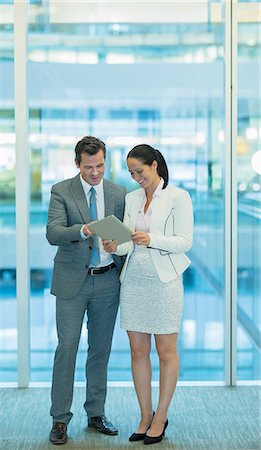 Businessman and businesswoman using digital tablet in office Stock Photo - Premium Royalty-Free, Code: 6113-08550022