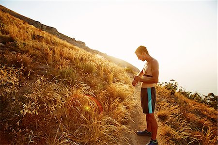 simsearch:6113-08550157,k - Bare chested male runner on trail checking smart watch Stock Photo - Premium Royalty-Free, Code: 6113-08550173