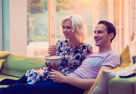 simsearch:649-06489213,k - Couple watching TV and eating popcorn on living room sofa Stock Photo - Premium Royalty-Free, Code: 6113-08550104
