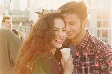 simsearch:6113-08568531,k - Laughing young couple hugging at rooftop party Stock Photo - Premium Royalty-Free, Code: 6113-08568476