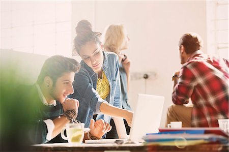 Creative young business people working at laptop in office Stock Photo - Premium Royalty-Free, Code: 6113-08568487