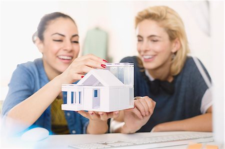 Young female architects assembling house model Stock Photo - Premium Royalty-Free, Code: 6113-08568547