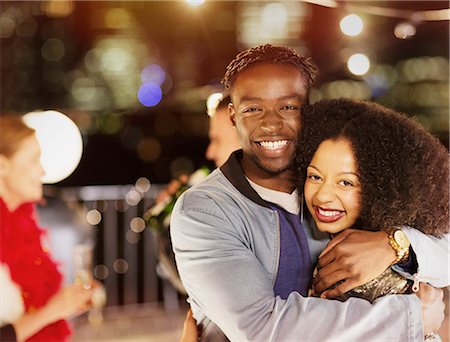 simsearch:6113-08568786,k - Portrait smiling young couple hugging at party Foto de stock - Sin royalties Premium, Código: 6113-08568560