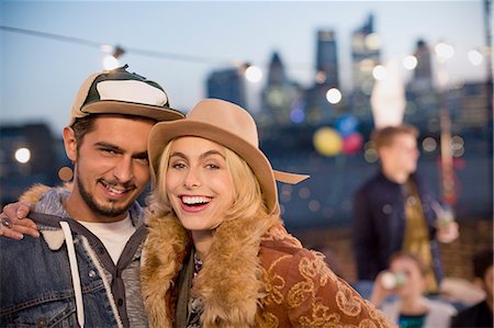 Portrait smiling young couple hugging at nighttime rooftop party Stock Photo - Premium Royalty-Free, Code: 6113-08568586