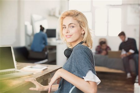 simsearch:6113-08568522,k - Portrait confident young female college student with headphones at laptop Fotografie stock - Premium Royalty-Free, Codice: 6113-08568503