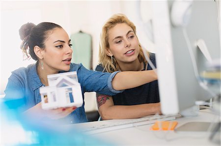 discussion of plan two women - Female architects holding house model at computer in office Stock Photo - Premium Royalty-Free, Code: 6113-08568506