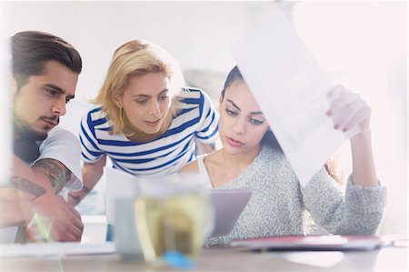 Creative young business people reviewing paperwork Stock Photo - Premium Royalty-Free, Code: 6113-08568514