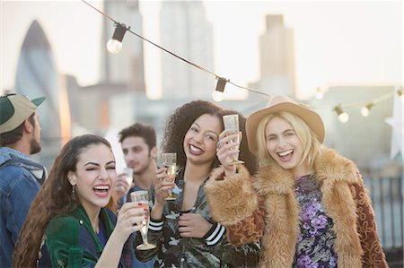 social drink city cheers - Portrait enthusiastic young women drinking champagne at rooftop party Stock Photo - Premium Royalty-Free, Code: 6113-08568607