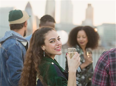 simsearch:6113-08568531,k - Portrait smiling young woman drinking champagne at rooftop party Stock Photo - Premium Royalty-Free, Code: 6113-08568611