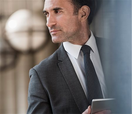 simsearch:6124-08907874,k - Pensive corporate businessman with digital tablet looking away Stock Photo - Premium Royalty-Free, Code: 6113-08568630