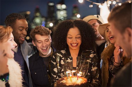 rooftop party - Friends celebrating young woman's birthday with cake and candles Stock Photo - Premium Royalty-Free, Code: 6113-08568780