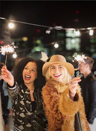 social event - Young women waving sparklers at rooftop party Photographie de stock - Premium Libres de Droits, Code: 6113-08568792