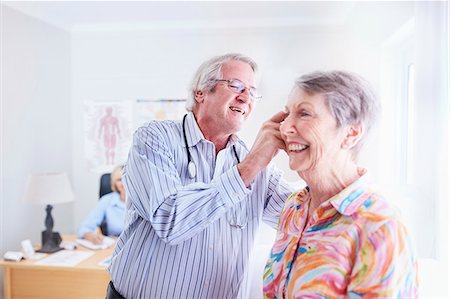 Doctor examining senior woman's ear in checkup Stock Photo - Premium Royalty-Free, Code: 6113-08568722