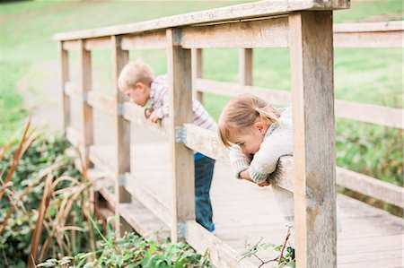 Toddler children leaning on footbridge railing in park Stock Photo - Premium Royalty-Free, Code: 6113-08521263