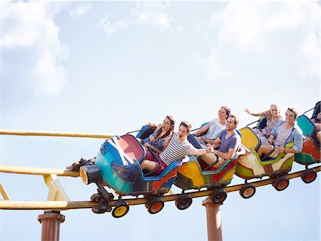 simsearch:6113-08521335,k - Friends cheering and riding roller coaster at amusement park Stock Photo - Premium Royalty-Free, Code: 6113-08521345