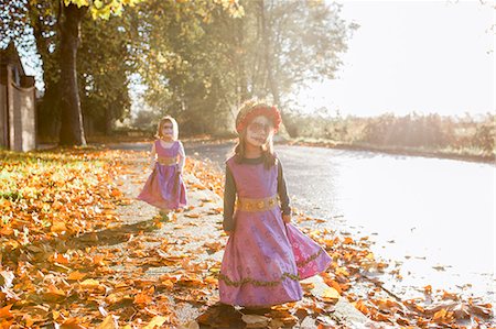 simsearch:6113-08521307,k - Toddler girls in Halloween costumes walking in autumn leaves Fotografie stock - Premium Royalty-Free, Codice: 6113-08521306