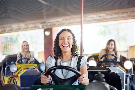 dirección (conducir) - Portrait smiling young woman riding bumper cars at amusement park Foto de stock - Sin royalties Premium, Código: 6113-08521314