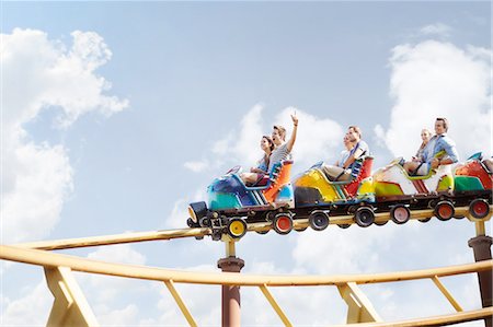 simsearch:6113-08521335,k - Friends cheering riding roller coaster at amusement park Stock Photo - Premium Royalty-Free, Code: 6113-08521335