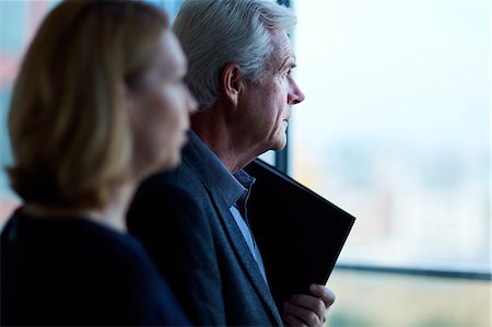 simsearch:6113-08659626,k - Pensive businessman and businesswoman looking through window Photographie de stock - Premium Libres de Droits, Code: 6113-08521429