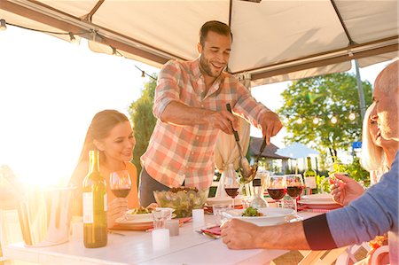 serving food - Man serving salad at sunny patio table Stock Photo - Premium Royalty-Free, Code: 6113-08521567