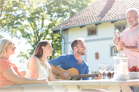 simsearch:6113-08521566,k - Father opening bottle of rose wine for family at sunny patio table Stock Photo - Premium Royalty-Free, Code: 6113-08521569