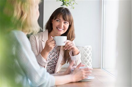 people candid happy - Smiling women drinking coffee at cafe window Stock Photo - Premium Royalty-Free, Code: 6113-08521578