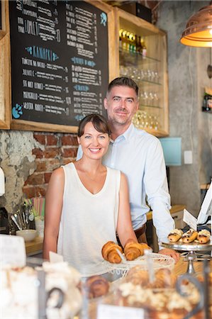 simsearch:614-08148352,k - Portrait smiling cafe owner couple behind the counter Foto de stock - Sin royalties Premium, Código: 6113-08521599