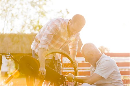 senior citizen with adult child - Father and adult son fixing bicycle Stock Photo - Premium Royalty-Free, Code: 6113-08521522