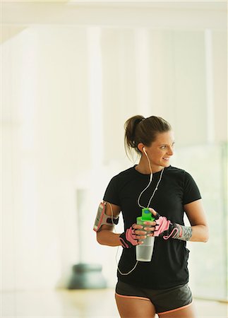 Smiling woman taking a break drinking water in gym studio Stock Photo - Premium Royalty-Free, Code: 6113-08536042