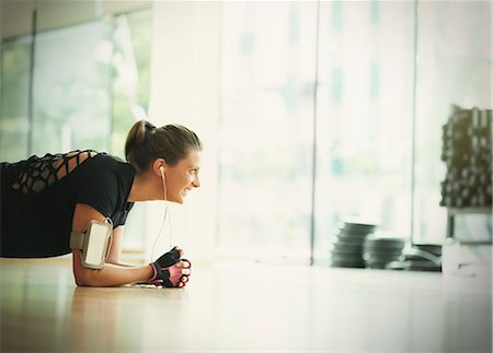 fit tech - Smiling woman in plank position on gym studio floor Stock Photo - Premium Royalty-Free, Code: 6113-08536056