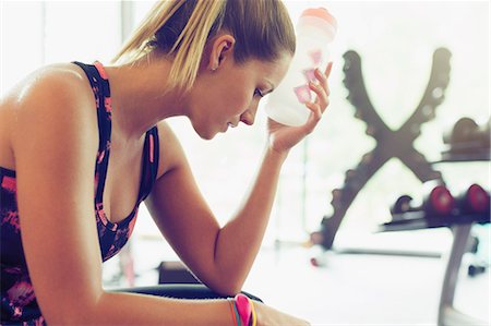 simsearch:6113-08536110,k - Tired woman cooling forehead with water bottle at gym Stock Photo - Premium Royalty-Free, Code: 6113-08536005