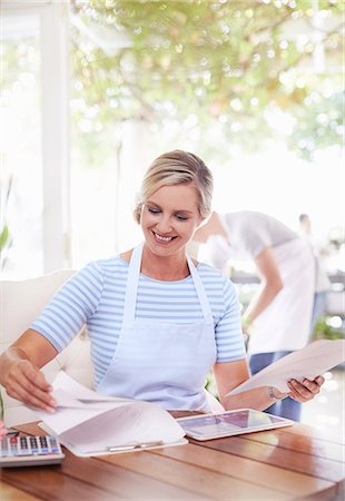 Smiling business owner doing paperwork Stock Photo - Premium Royalty-Free, Code: 6113-08536184