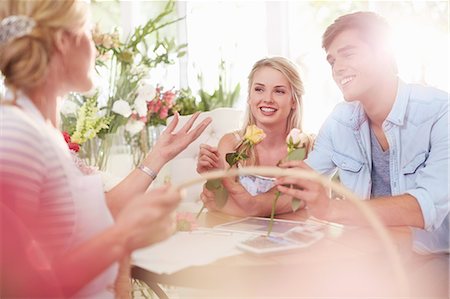 Florist discussing roses with couple in flower shop Foto de stock - Sin royalties Premium, Código: 6113-08536188